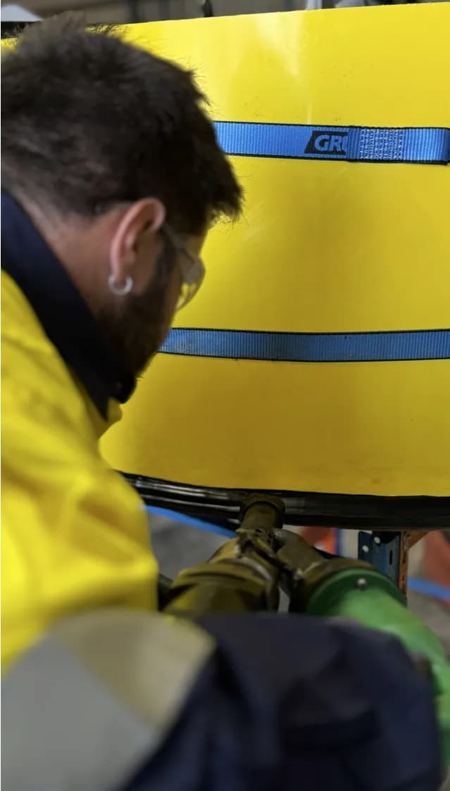 Polyline worker extrusion-welding an HDPE pump float