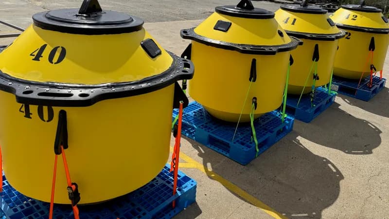 Numbered yellow HDPE survey buoys ready for deployment