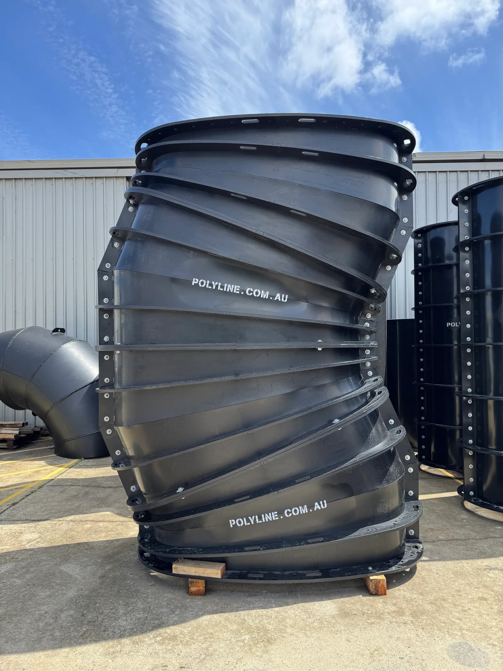 Large-diameter segmented HDPE bend, bolted and standing on timber bearers