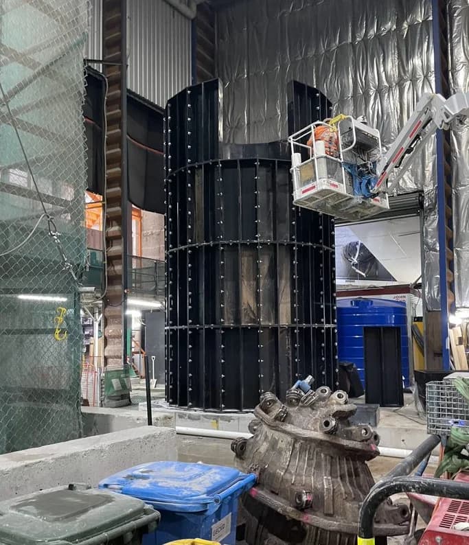 Modular HDPE ventilation shaft being assembled on site with an elevated work platform